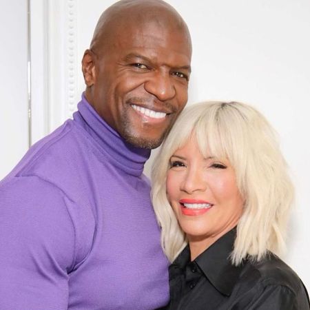 Terry Crews is wearing a purple turtleneck, and Rebecca Crews is wearing a black shirt.